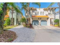 Two-story townhome with double garage and landscaped front yard at 104 S Moody Ave # 3, Tampa, FL 33609