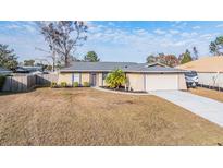 Single-story house with attached garage and fenced yard at 11201 Mercedes St, Spring Hill, FL 34609