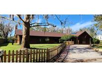 Ranch style home with wood siding, fenced yard, and a spacious driveway at 4747 Tamney Ln, Land O Lakes, FL 34639