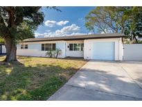 Updated Ranch home with light blue garage door and manicured lawn at 8462 8Th N Way, St Petersburg, FL 33702