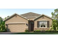 One-story home with tan siding, stone accents, and a two-car garage at 18212 Canopy Pl, Lakewood Ranch, FL 34211