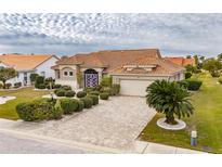 One-story home with tile roof, landscaping, and paver driveway at 2003 Captiva Ct, Sun City Center, FL 33573