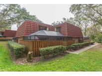 Brick townhouse with red tile roof, screened patio, and fenced yard at 2601 2Nd Ct, Palm Harbor, FL 34684