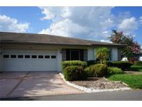 House exterior featuring a two-car garage and well-manicured landscaping at 1405 Langley Dr # 97, Sun City Center, FL 33573