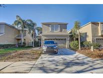Two-story house with attached garage and palm trees at 15521 Long Cypress Dr, Ruskin, FL 33573