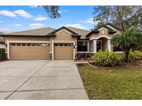 Attractive single-story home with three-car garage and manicured lawn at 20000 Outpost Pt Dr, Tampa, FL 33647