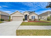 Single-story home with attached garage and landscaped lawn at 12645 Flatwood Creek Dr, Gibsonton, FL 33534