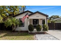 Charming bungalow with a white exterior, black accents, and landscaped front yard at 7209 N Highland Ave, Tampa, FL 33604