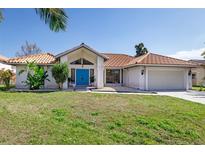 Single-story home with terracotta roof, attached garage, and landscaped lawn at 2250 Rio De Janeiro Ave, Punta Gorda, FL 33983