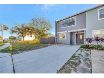 Two-story townhome with gray siding, dark door, and a paved driveway at 2820 S Pines Dr # 125, Largo, FL 33771