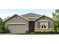 One-story house with a two-car garage, stone accents, and landscaping at 10574 Farm Hill Ave, Land O Lakes, FL 34638