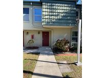 Inviting condo entry with red door and well-manicured landscaping at 1799 N Highland Ave # 44, Clearwater, FL 33755