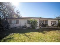 Ranch-style home with a well-manicured lawn and mature trees at 91 69Th N St, Clearwater, FL 33764