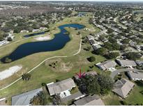 Aerial view showcasing home's location in a community near a golf course and pond at 1318 Leland Dr, Sun City Center, FL 33573