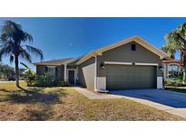Single-story house with a two-car garage and palm trees at 1610 Bonita Bluff Ct, Ruskin, FL 33570