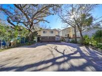 Two-story house with a double garage and a large driveway, surrounded by lush landscaping at 1745 E Mulberry Dr, Tampa, FL 33604