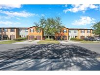 Exterior view of townhouses with attached garages and lush landscaping at 2517 Edgewater Falls Dr, Brandon, FL 33511