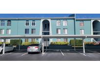 Building exterior featuring teal painted walls, covered parking, and landscaping at 255 114Th N Ave # 4, St Petersburg, FL 33716