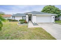 Single-story home with attached garage and well-manicured lawn at 3127 Ivyhill Ct, Holiday, FL 34691