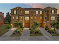 Tan three-story townhome with two-car garage and lush landscaping at 8958 White Sage Loop, Lakewood Ranch, FL 34202