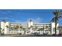 Condominium building exterior, featuring a light-blue facade and palm trees at 18325 Gulf Blvd # 407, Redington Shores, FL 33708