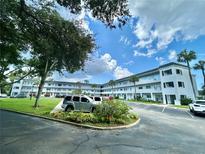 Exterior view of a condo building with parking and landscaping at 2002 Australia E Way # 38, Clearwater, FL 33763