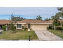 Single-story home with attached garage and well-manicured lawn at 2267 Heron Cir, Clearwater, FL 33762