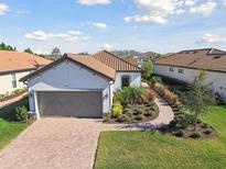 Single-story home with gray garage door and landscaped yard at 4316 Cairoli Ct, Wesley Chapel, FL 33543