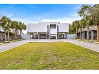 Modern two-story home with a carport and manicured lawn at 6 Treasure Ln, Treasure Island, FL 33706