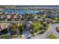 Aerial view of two story house with a large backyard and community lake at 10105 Celtic Ash Dr, Ruskin, FL 33573