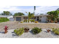 House exterior featuring a large driveway and well-manicured landscaping at 1217 De Narvaez Ave, Bradenton, FL 34209