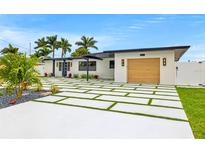 Modern home showcasing a paver driveway with turf accents and lush landscaping at 407 41St Ave, St Pete Beach, FL 33706