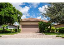 Single-story home with attached garage and landscaped yard at 5548 Sentiero Dr, Nokomis, FL 34275