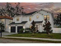 Stunning two-story home with a white exterior, dark accents, and a manicured lawn at 4306 W Barcelona St, Tampa, FL 33629