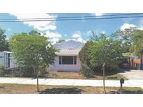 Charming single-story home with lush landscaping, a covered carport, and a well-maintained front yard at 509 Rosery Nw Rd, Largo, FL 33770