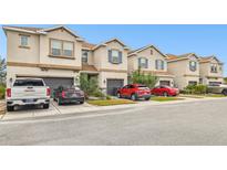 Tan townhouses with gray garage doors and blue shutters at 8126 Muddy Pines Pl, Tampa, FL 33635