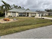 Well-maintained house with a gray roof and landscaped lawn at 943 Columbia Ter, Port Charlotte, FL 33948
