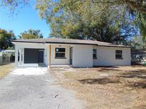 Newly renovated home with a white brick exterior and landscaping at 10322 N Oakleaf Ave, Tampa, FL 33612