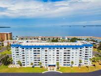 Aerial view of a waterfront condo building with a blue roof and ocean views at 7 Elgin Pl # 812, Dunedin, FL 34698