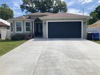 Charming single-story home with a well-manicured lawn, inviting curb appeal, and an attached two-car garage at 7819 N Cortez St, Tampa, FL 33614