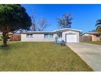 Charming single-story home featuring a well-manicured lawn, inviting curb appeal, and attached single car garage at 8630 118Th St, Seminole, FL 33772