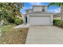 Two-story house with white siding, a two-car garage, and a landscaped yard at 1107 Seminole Sky Dr, Ruskin, FL 33570