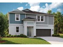 Two-story home with gray and teal siding, dark garage door, and landscaped lawn at 14445 Meadow Bird Ave, Riverview, FL 33579