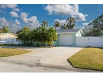 Light teal house with white fence and palm trees at 3501 70Th N Way, St Petersburg, FL 33710