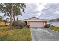 Single-story house with attached garage and landscaped lawn at 4013 Lexington Ct, Largo, FL 33771