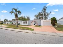 Updated single story home with a large driveway and a palm tree in the front yard at 3403 Overland Dr, Holiday, FL 34691