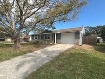 Newly renovated home with gray exterior, stone accents, and a spacious driveway at 7318 Dianne Dr, New Port Richey, FL 34652