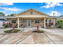 Cute one-story home with stone exterior, covered porch, and landscaped yard at 8 Citrus Dr, Palm Harbor, FL 34684