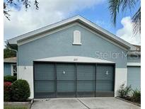 House exterior featuring a two-car garage and well-manicured landscaping at 1213 Huntington Greens Dr, Sun City Center, FL 33573