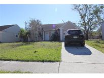Tan one-story house with a driveway and small yard at 1621 Crossridge Dr, Brandon, FL 33510